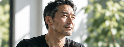 窓辺で外を見る男性