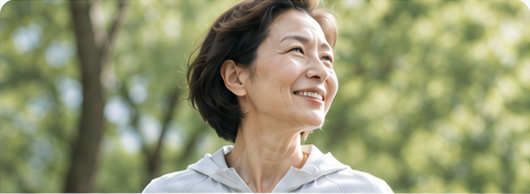 緑の中で笑顔を見せる女性